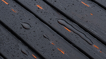 Rainwater on textured black wooden surface outdoor setting close-up photography natural environment artistic composition
