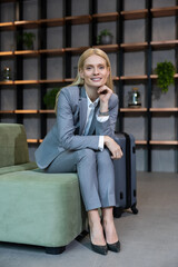 Pretty long-haired blonde caucasian woman in a nice suit looking contented