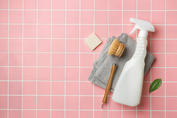 Spray bottle, cleaning brush for and sponge on pink tile. Flat lay eco cleaning products. Cleaner...
