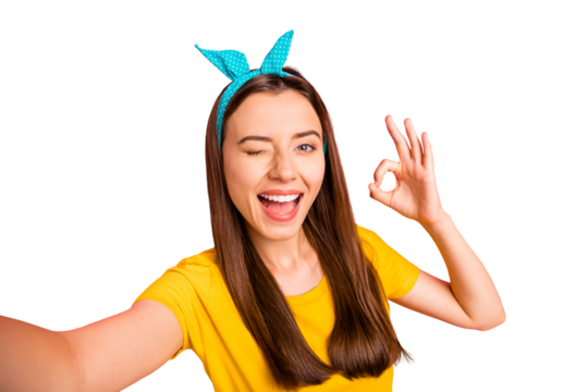 Close up photo of cheerful person making ok sign wearing yellow t-shirt isolated over pink background