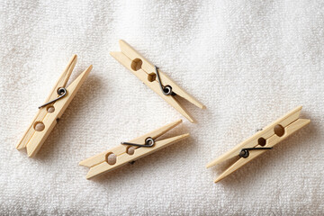 Wooden clothespins resting on soft white fabric after a laundry session
