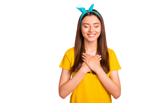 Portrait of cute hipster closing her eyes touching chest wearing yellow t-shirt isolated over pink background
