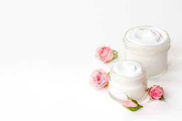 Closeup of pink roses essence skin care cream with flowers and petals