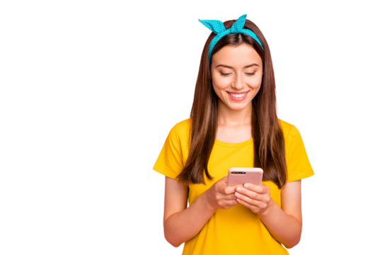 Portrait of lovely person holding looking at device smiling wearing yellow t-shirt isolated over pink background