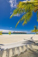 Tropical beach panorama as summer relax landscape with beach swing or hammock hang on palm tree over white sand sea beach banner. Amazing beach vacation summer holiday concept. Luxury romantic travel