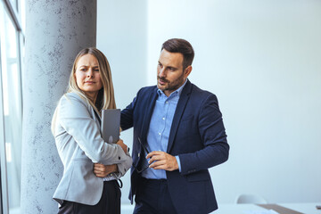 Two Office Colleagues Engaged in a Tense Discussion in a Workplace Setting