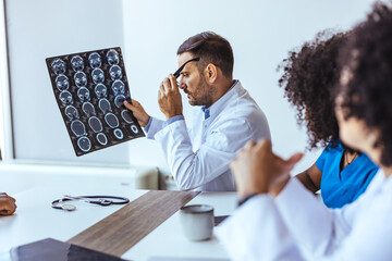 Medical Professionals Analyzing Brain Scans During a Team Meeting