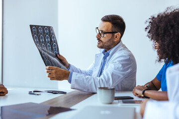 Doctor Discussing Brain Scans with Medical Team in a Conference Room