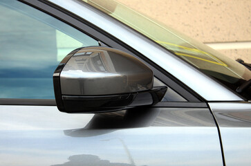 Grey Rear view mirror new car. Side rear-view mirror on a modern car. Close up rearview mirror new car. Grey car side mirror in exterior. 