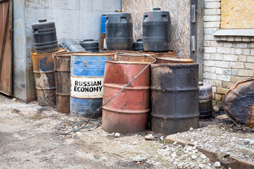 Rusty Barrels with RUSSIAN ECONOMY Label in Industrial Setting