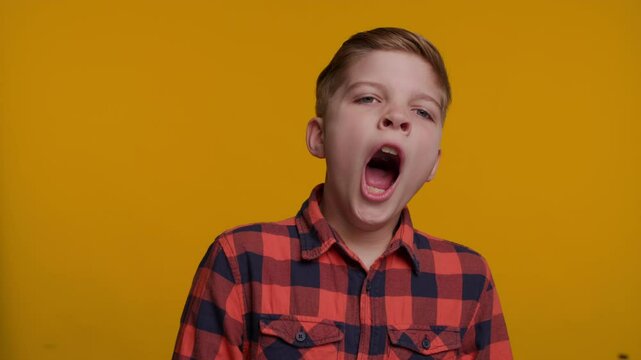 Boy Yawning on Yellow Background