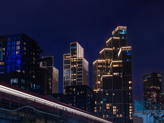 Night Cityscape with Skyscrapers and Passing Train in London