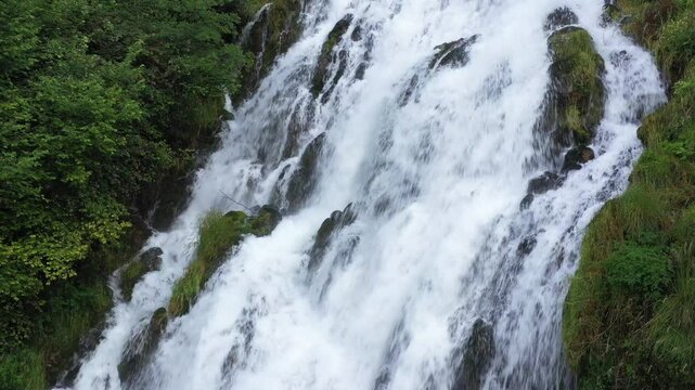 Wild Serenity: Close-Up of a Waterfall Amid Lush Green Wilderness