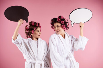 Attractive mother and daughter with hair curlers