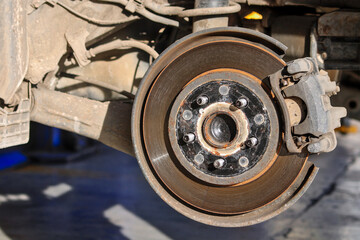 Close-up of a car brake disc, showing wear and rust. This image is perfect for showing car repair, maintenance or mechanical engineering.