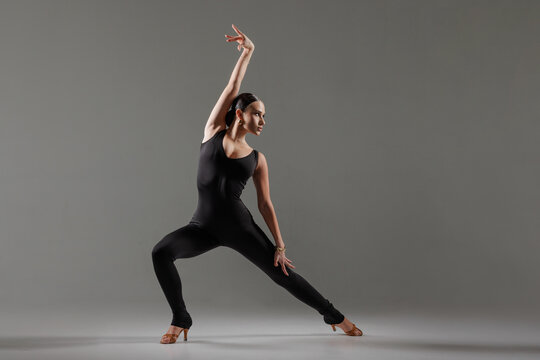 Dynamic dance solo. Woman dancing bachata on gradient yellow-orange background in neon light. Dance concept, lessons, school