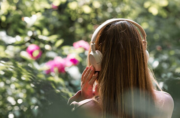 A beautiful 35-year-old woman listens to music with large headphones. Close-up. Harmony, relaxation...