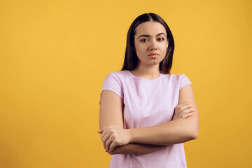 Obraz premium Portrait of unsure young girl with crossed arms.