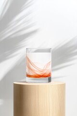 Translucent glass with swirling colors rests on wooden pedestal,