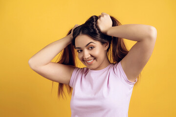 Fototapeta premium Young joyous girl ruffles long hair on head.