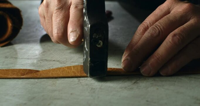 Super Slow Motion Close Up of Artisan Handcrafting Leather with Precision Hammer - Close-Up of Traditional Tooling Technique on Raw Leather Strip in Workshop at 1000 fps.