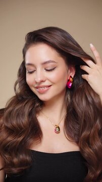 Beautiful model women have wave and shiny hair . Brunette girl with curly hairstyle, earrings and jewelry. Slow motion video