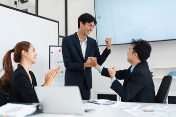 Celebrating Success and Team Spirit. Colleagues celebrating achievements and teamwork during a meeting.