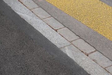 Frisch geteerter Rollstuhlgängiger Barrierefreier Gehweg bei Fussgängerstreifen. auf Strasse, Dunkler frischer Asphalt