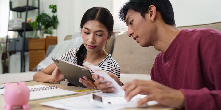 Finances and Collaboration. A couple discussing their financial plan using a tablet and documents for budgeting together.