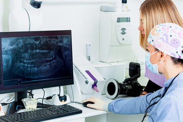 Dentists examining a dental radiography on a computer in a dental clinic