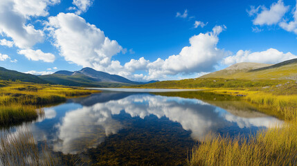 Obraz premium Serene landscape with a tranquil lake reflecting clouds and mountains under a bright blue sky showcasing nature's beauty and harmony healthy living concept