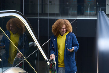 Young man with skateboard using smartphone