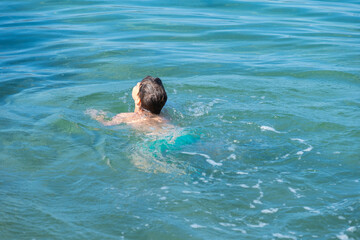 child swims in in open water, sea, confronting fear deep water and potential dangers drowning,...