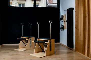 Pilates wunda chairs in an empty gym with copy space