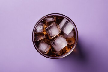 Top view of glass filled with ice cubes and brown beverage