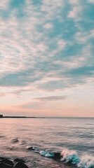 Obraz premium Tranquil sunset over ocean with gentle waves and cloudy sky