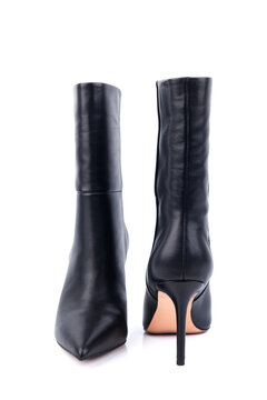 Black leather women's ankle boots with high heels on a white background. Women's stylish autumn shoes. Spring elegant women's boots with heels