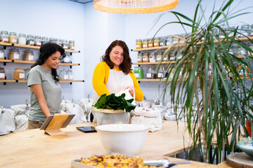 Shop assistants serving a customer buying fresh organic products in a zero waste shop