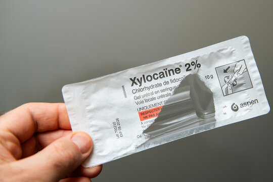 Paris, France - Mar 10, 2025: A person holds a blister package of Xylocaine 2 percent urethral gel with French labeling showing instructions and sterile sealing from the Aspen pharmaceutical company