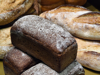 Freshly baked bread in a bakery showcasing various loaves with a focus on rustic textures and artisan craftsmanship