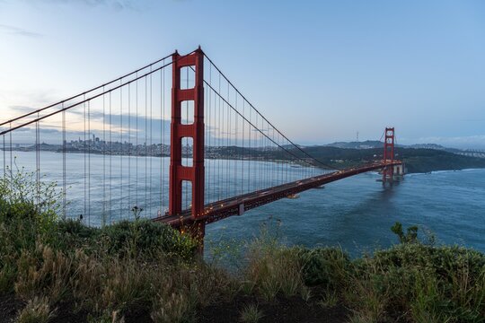 Golden Gate Bridge at dusk with the skyline of San Francisco, showcasing iconic architecture