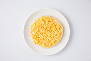 Mimosa salad on a white plate against a white background, top view