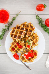 Delicious potato waffles with red caviar on a plate