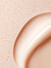 Fototapeta premium Close-up of a liquid foundation or concealer swatch. the swatch is in the shape of a curved line, with a light peach-colored liquid inside.