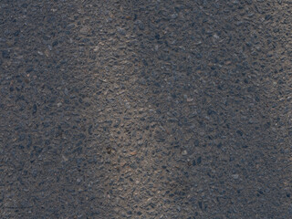 Close-up of asphalt surface rough texture with small stones.