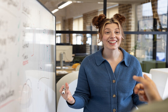 Young employee brainstorming ideas on a whiteboard
