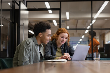 Happy Colleagues Working Together on Laptop