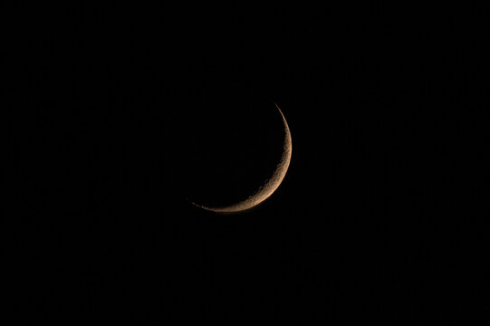 cienki rogal księżyca na czarnym tle nieba nocnego