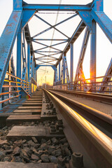 Most kolejowy z metalową niebieską konstrukcją Kładka z torami kolejowymi pociąg&oacute;w towarowych