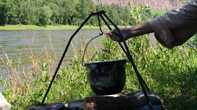 Steaming kettle over open fire symbol of traditional outdoor meals Warmth of flickering flames and fresh air combine to create a comforting and nostalgic campfire moment Concept of outdoor recreation